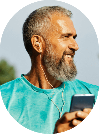 Hombre con auriculares sonriendo con el móvil en la mano